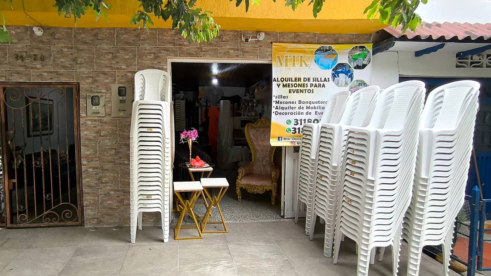 Entrada de la bodega de MTK en la Carrera 7 #31-20, Las Granjas, con las sillas apiladas y el aviso de MTK