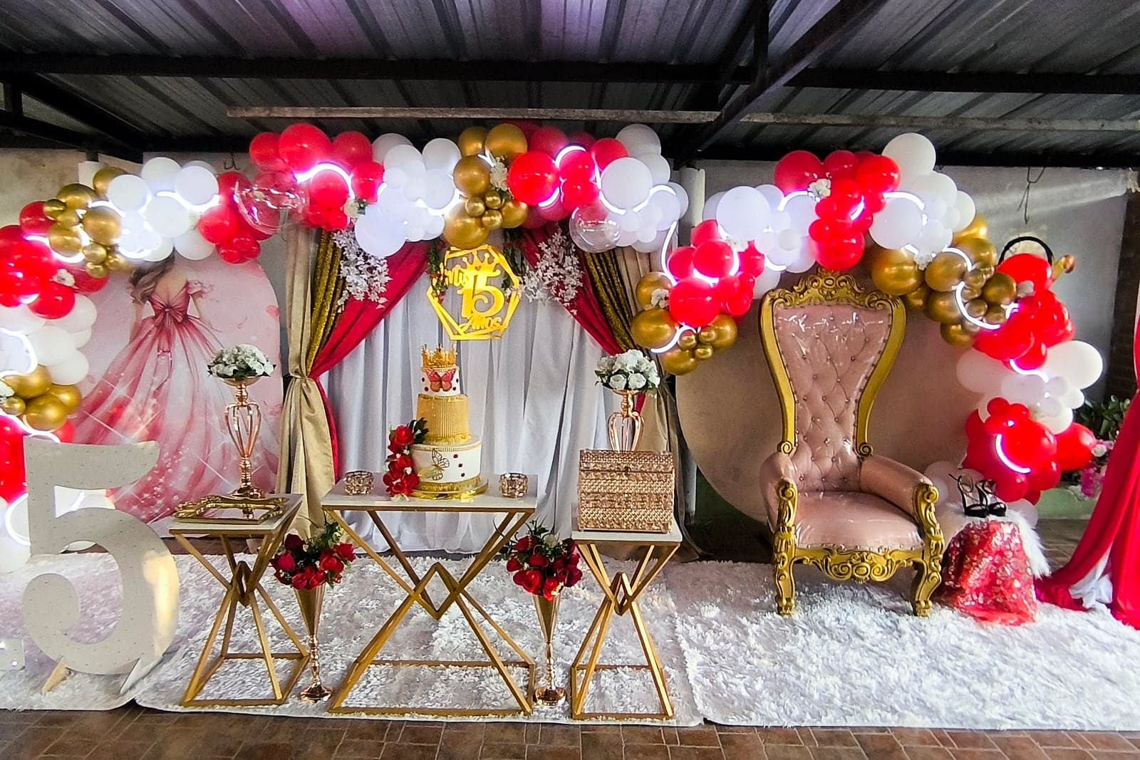 Decoración de quince años en rojo, blanco y dorado con trono y mesa de torta