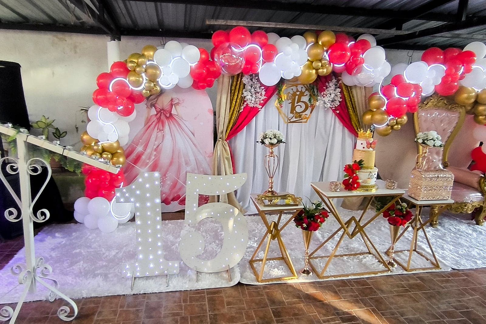 Arco de globos rojo, blanco y dorado con números 15 iluminados